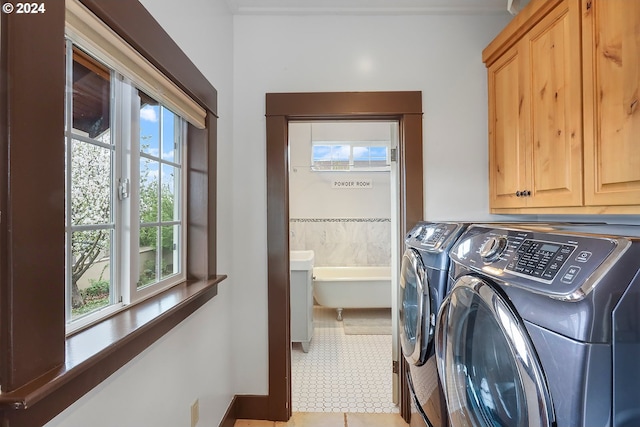 clothes washing area featuring washer and dryer and cabinets