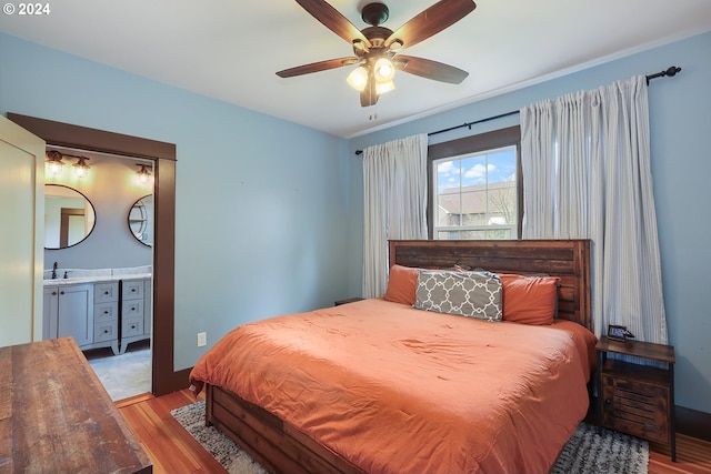 bedroom with sink, light hardwood / wood-style floors, and ceiling fan