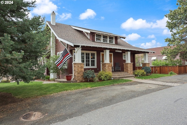 craftsman-style house with a front lawn and covered porch