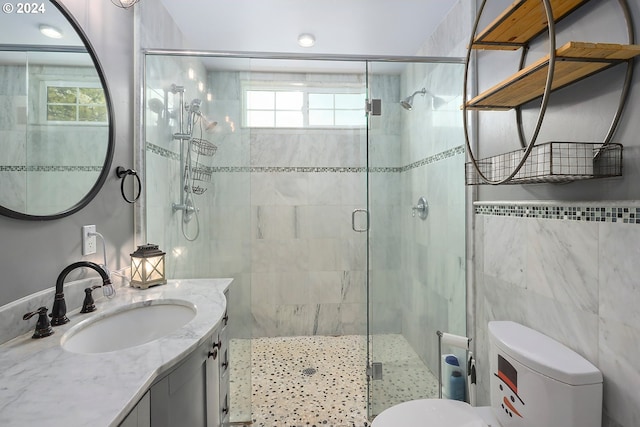 bathroom featuring vanity, toilet, tile walls, and walk in shower