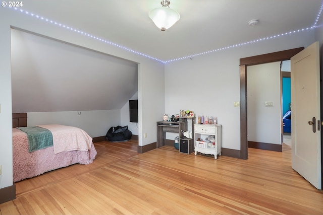 bedroom with lofted ceiling and wood-type flooring