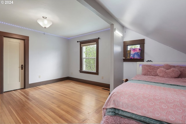 bedroom with lofted ceiling and light hardwood / wood-style floors