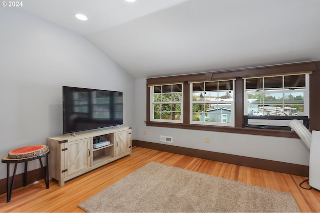 living room featuring lofted ceiling and light hardwood / wood-style floors