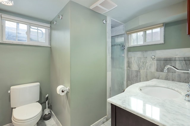 bathroom featuring a shower with door, vanity, and toilet