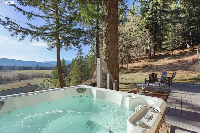 view of pool featuring a deck with mountain view and a hot tub