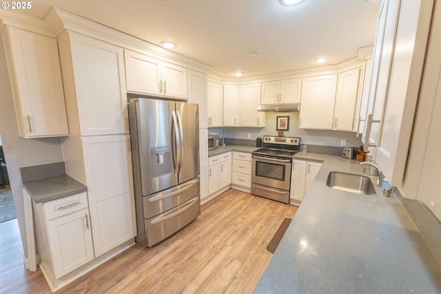 kitchen with sink, light hardwood / wood-style flooring, white cabinets, and appliances with stainless steel finishes