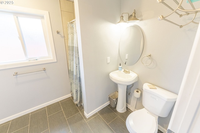 bathroom with a shower with shower curtain and toilet