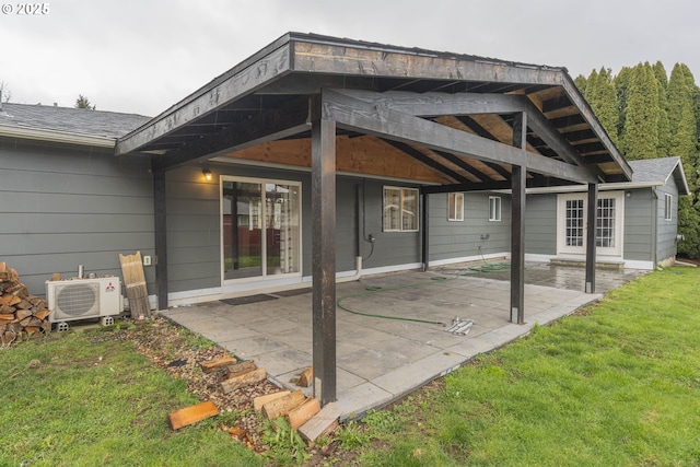 back of house featuring a lawn, a patio, and ac unit