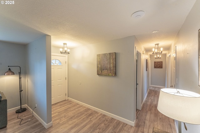 interior space with an inviting chandelier, hardwood / wood-style flooring, and a textured ceiling