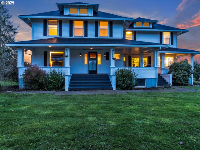 traditional style home featuring a porch and a front lawn