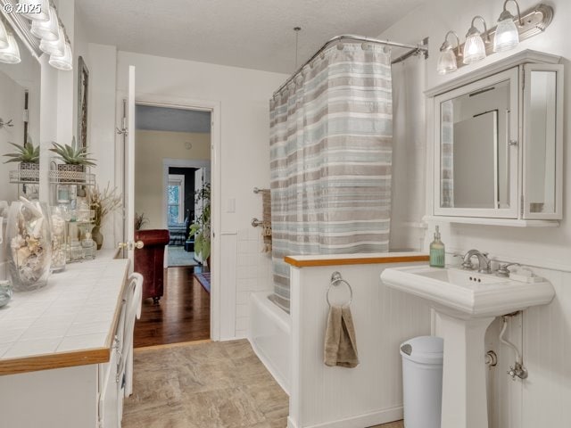 bathroom featuring a sink and shower / bath combination with curtain