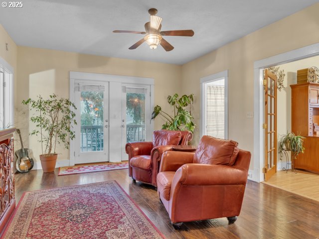 living area featuring wood finished floors, a wealth of natural light, and ceiling fan