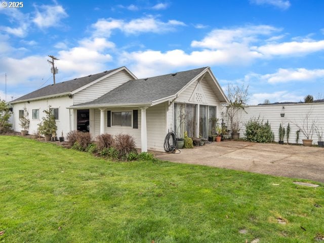 back of property with a yard and a patio area