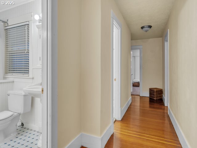 hallway featuring wood finished floors and baseboards