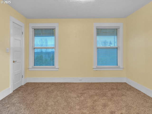 carpeted spare room with baseboards