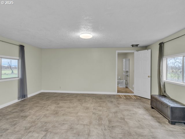 spare room with baseboards and a textured ceiling