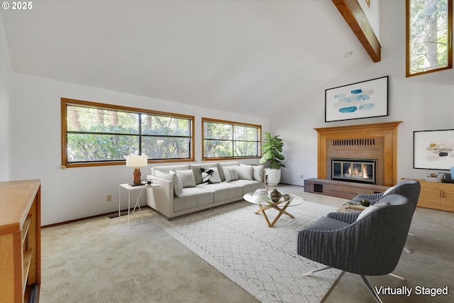 carpeted living area with plenty of natural light, beam ceiling, a fireplace, baseboards, and high vaulted ceiling