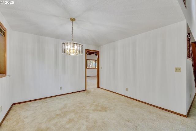 unfurnished room featuring a chandelier, carpet, baseboards, and a textured ceiling