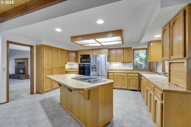 kitchen with black appliances, light carpet, a center island, a sink, and recessed lighting
