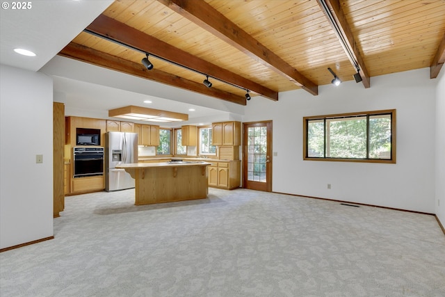 kitchen featuring black appliances, wood ceiling, a kitchen island, baseboards, and light carpet