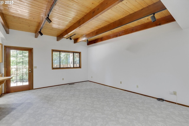 carpeted empty room featuring wooden ceiling, rail lighting, beamed ceiling, and baseboards