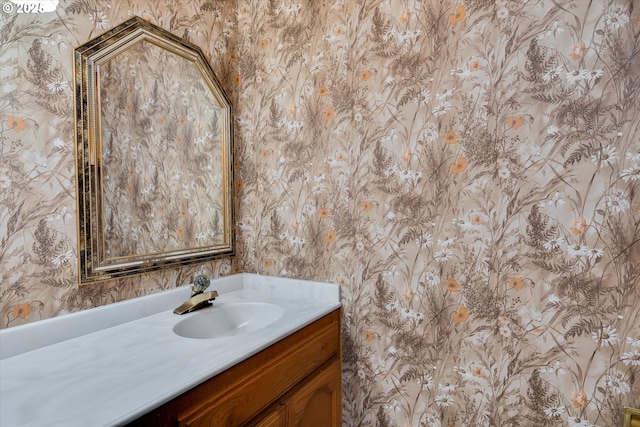 bathroom with wallpapered walls and vanity
