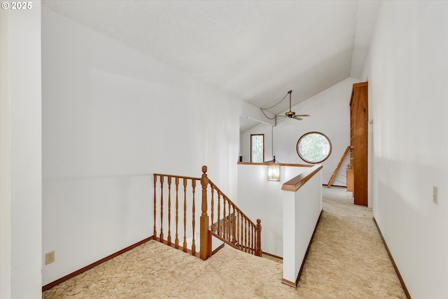 staircase featuring carpet, vaulted ceiling, and baseboards