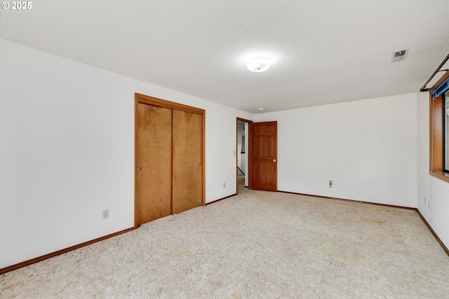 unfurnished bedroom with carpet, a closet, and baseboards