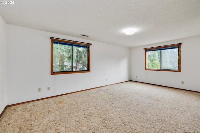 unfurnished room with carpet, a textured ceiling, and baseboards