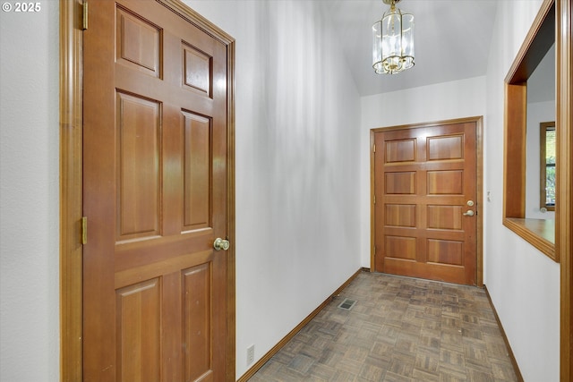 foyer featuring a chandelier and baseboards