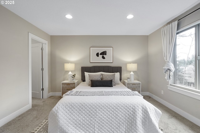 bedroom featuring multiple windows, light carpet, and baseboards