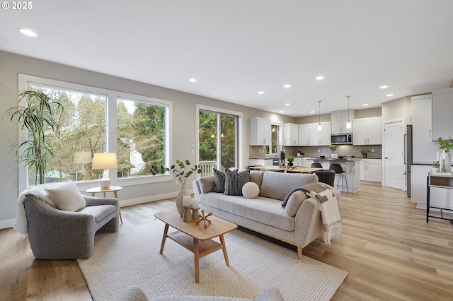 living room with light wood-style flooring, baseboards, and recessed lighting