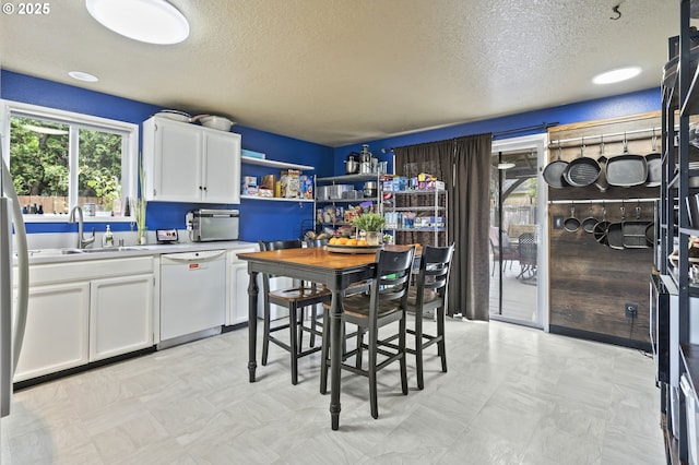 14717 NE 51st St, Vancouver, WA 98682 - kitchen with white dishwasher, a sink, a textured ceiling, white cabinets, and light countertops