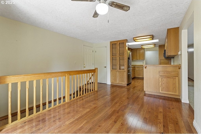 540 NE 23rd Pl, Gresham, OR 97030 - kitchen featuring dark wood finished floors, stainless steel refrigerator with ice dispenser, a ceiling fan, and a textured ceiling