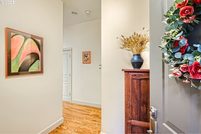 hallway with baseboards and wood finished floors