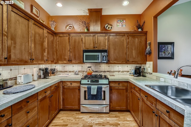 kitchen featuring a sink, light countertops, brown cabinets, and stainless steel appliances