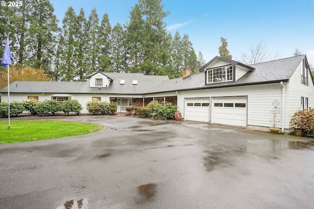 view of front facade with aphalt driveway, a garage, and a shingled roof