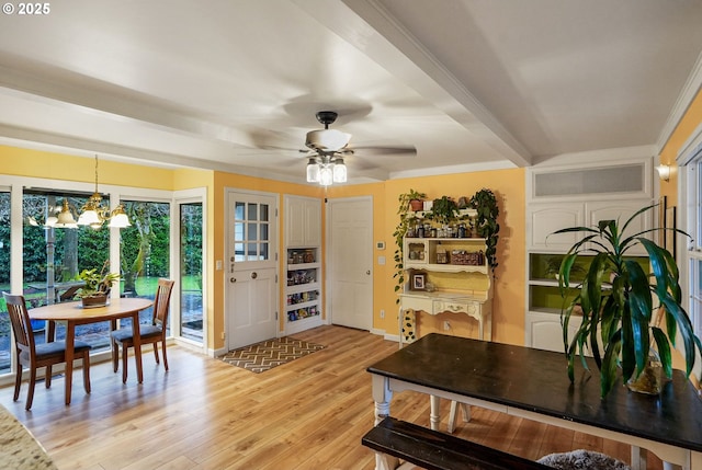 dining space with ceiling fan with notable chandelier, beamed ceiling, light wood-style floors, and ornamental molding