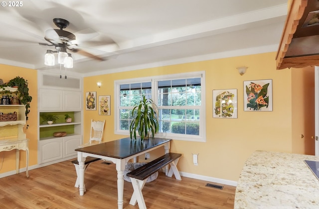 dining space featuring visible vents, light wood-style flooring, a ceiling fan, and baseboards