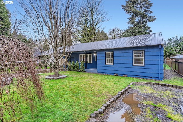 ranch-style home featuring metal roof, crawl space, a front yard, and fence