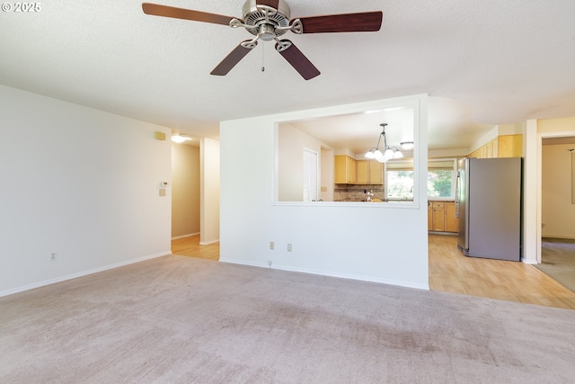 20753 SW Martinazzi Ave, Tualatin, OR 97062 - unfurnished living room featuring a chandelier, light carpet, a ceiling fan, and baseboards