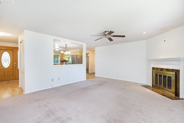 20753 SW Martinazzi Ave, Tualatin, OR 97062 - unfurnished living room featuring light colored carpet, ceiling fan, a fireplace with flush hearth, a chandelier, and baseboards