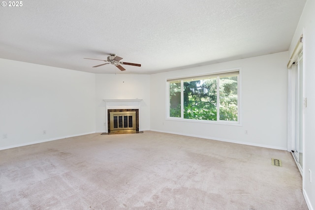 20753 SW Martinazzi Ave, Tualatin, OR 97062 - unfurnished living room with ceiling fan, a fireplace with flush hearth, a textured ceiling, carpet flooring, and baseboards