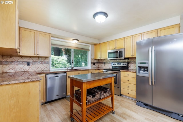 20753 SW Martinazzi Ave, Tualatin, OR 97062 - kitchen featuring stainless steel appliances, a sink, light brown cabinetry, and light wood-style floors