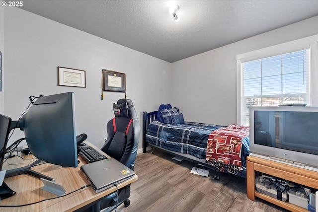 bedroom featuring a textured ceiling and wood finished floors