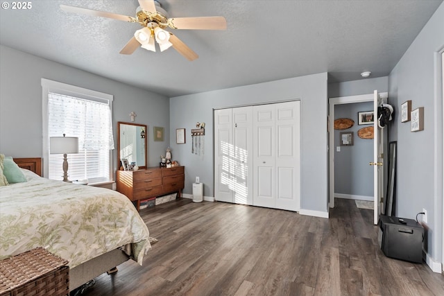 bedroom with dark wood-style floors, a closet, baseboards, and a textured ceiling