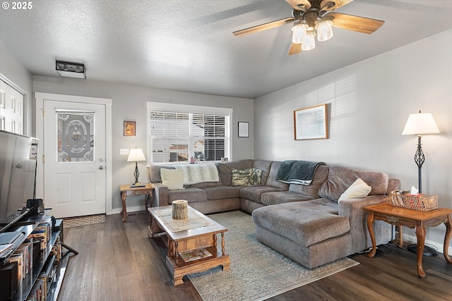 living area featuring baseboards, a textured ceiling, a ceiling fan, and dark wood-style flooring