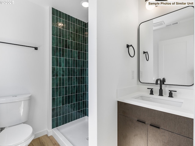 3827 N Willis Blvd, Portland, OR 97217 - full bath with tiled shower, toilet, baseboards, vanity, and wood finished floors