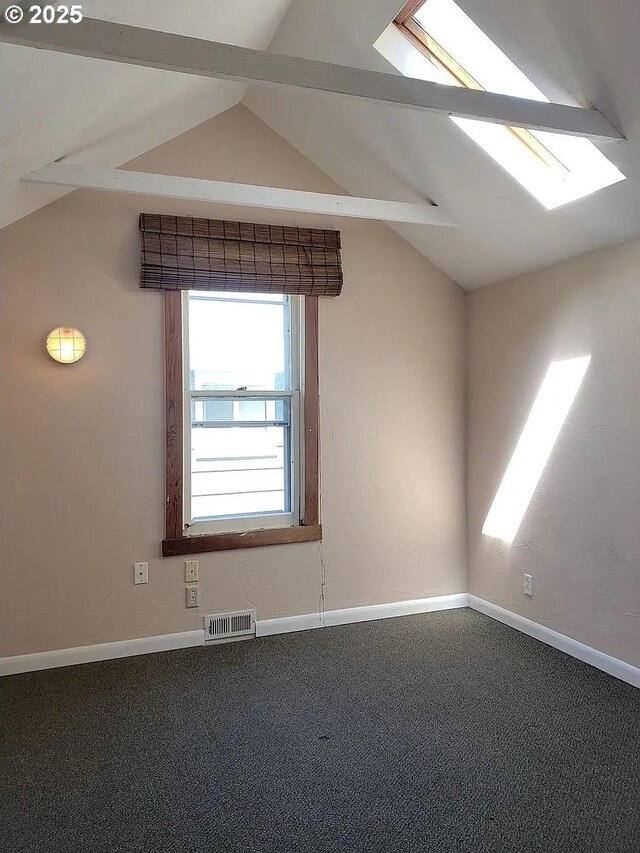 spare room featuring lofted ceiling, visible vents, and baseboards