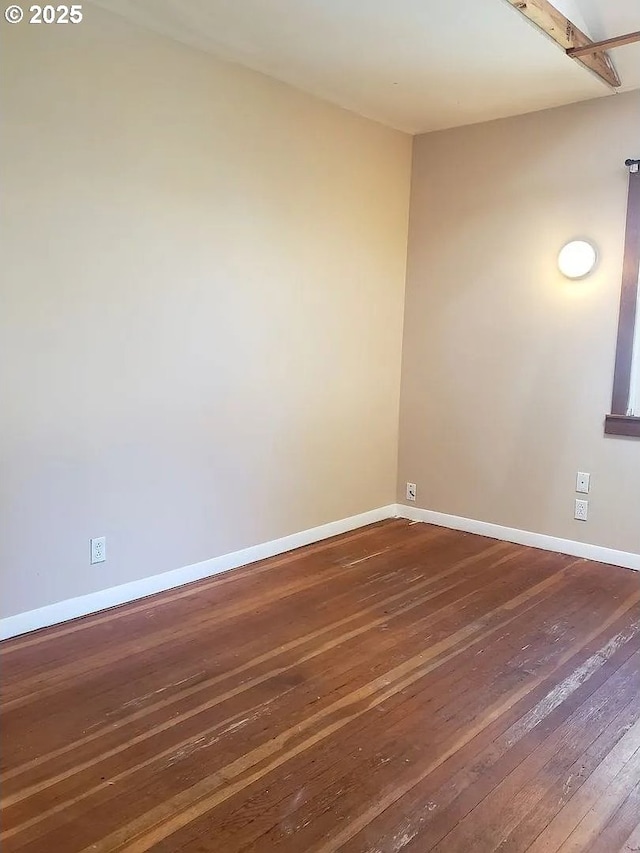 unfurnished room with dark wood-style flooring and baseboards